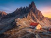 Famous Rifugio Locatelli alpine hut and cute small chapel with spectacular Monte Paterno peaks in background at sunset, Dolomites, Italy, Europe